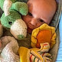 baby, infant, plush_toy, blanket, blue_cushion, striped_blanket, yellow_edge, soft_texture, cute, child, toddler, indoor, closeup, face, head, comfort, resting, sleepy, warm, snuggly