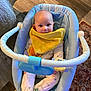 baby, blue_baby_seat, chewing, child, comfort, cozy, cute, face, frog_design, green_socks, home, indoor, infant, pajamas, rug, seated, smiling, toy_bar, wooden_floor, yellow_bib