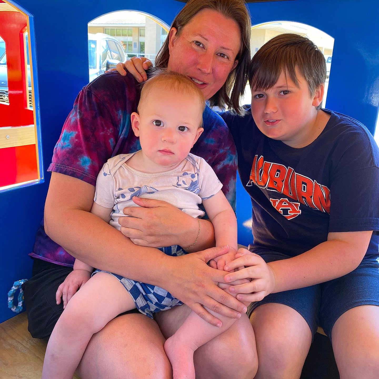 Grady is registered to the contest to win money with this photo: auburn_tshirt, baby, blue_interior, candid, casual_clothing, child, eyes, face, family, holding_hands, indoor, legs, play_structure, portrait, sitting, teenager, toddler, tshirt, woman, wooden_ceiling