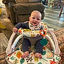 baby, walker, smile, infant, indoor, furniture, armchair, carpet, flooring, happy, child, toy, clothing, bib, foot, face, person, living_room, wooden_chair, colorful