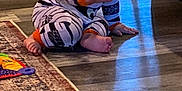 Grady joined the competition — help win amazing prizes! baby, carpet, child, crawling, cute, door, floor, foot, furniture, hand, home, indoor, infant, living_room, pacifier, pajamas, person, rug, striped_clothing, wooden_floor