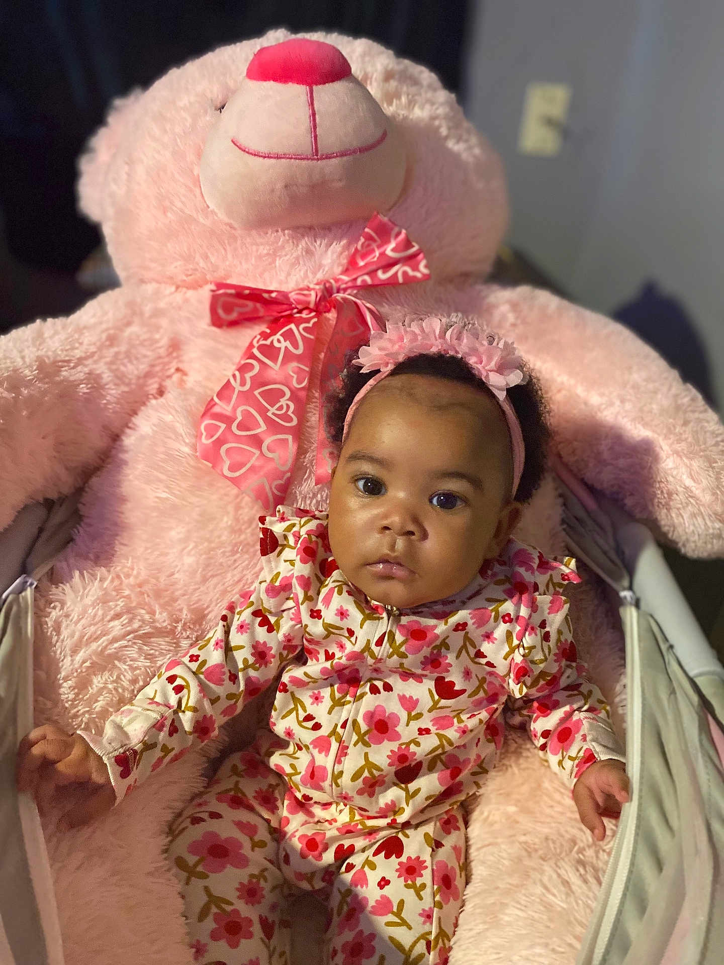 Amariaya is registered to the contest to win money with this photo: baby, child, comfort, cozy, cute, face, flower_pattern, furniture, headband, indoor, infant, pajamas, person, pink, plush_toy, portrait, seated, soft, teddy_bear, toy