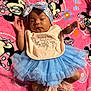 baby, infant, tutu, headband, bib, pink_blanket, minnie_mouse, cartoon, socks, frills, cute, lying_down, clothing, pattern, colorful, soft_texture, child, portrait, indoor, sleepy