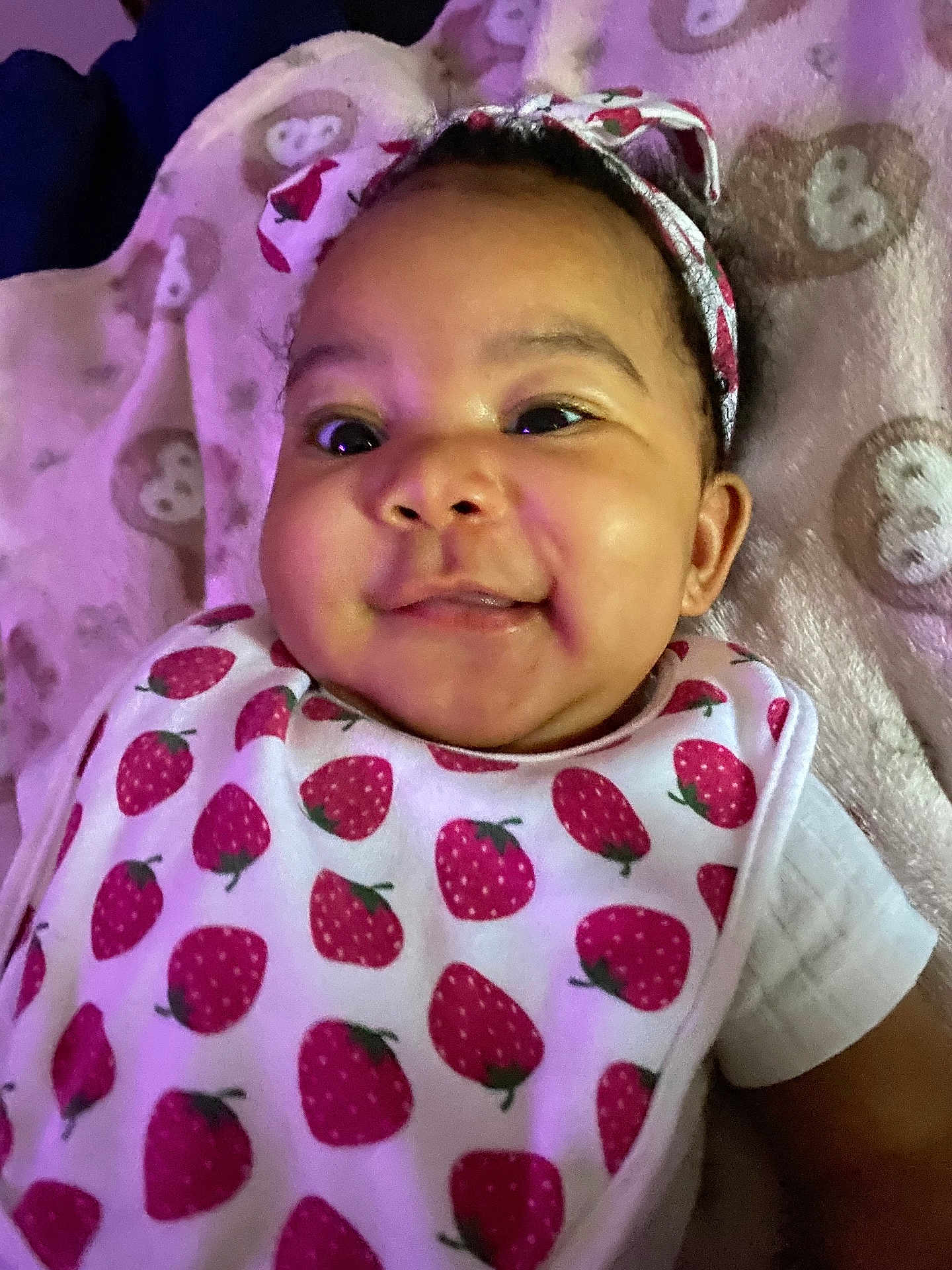 Amariaya joined the competition — help win amazing prizes! apparel, baby, bib, blanket, child, closeup, cute, face, happy, headband, indoors, infant, lying_down, monkey_pattern, person, portrait, skin, smiling, soft_lighting, strawberry_pattern