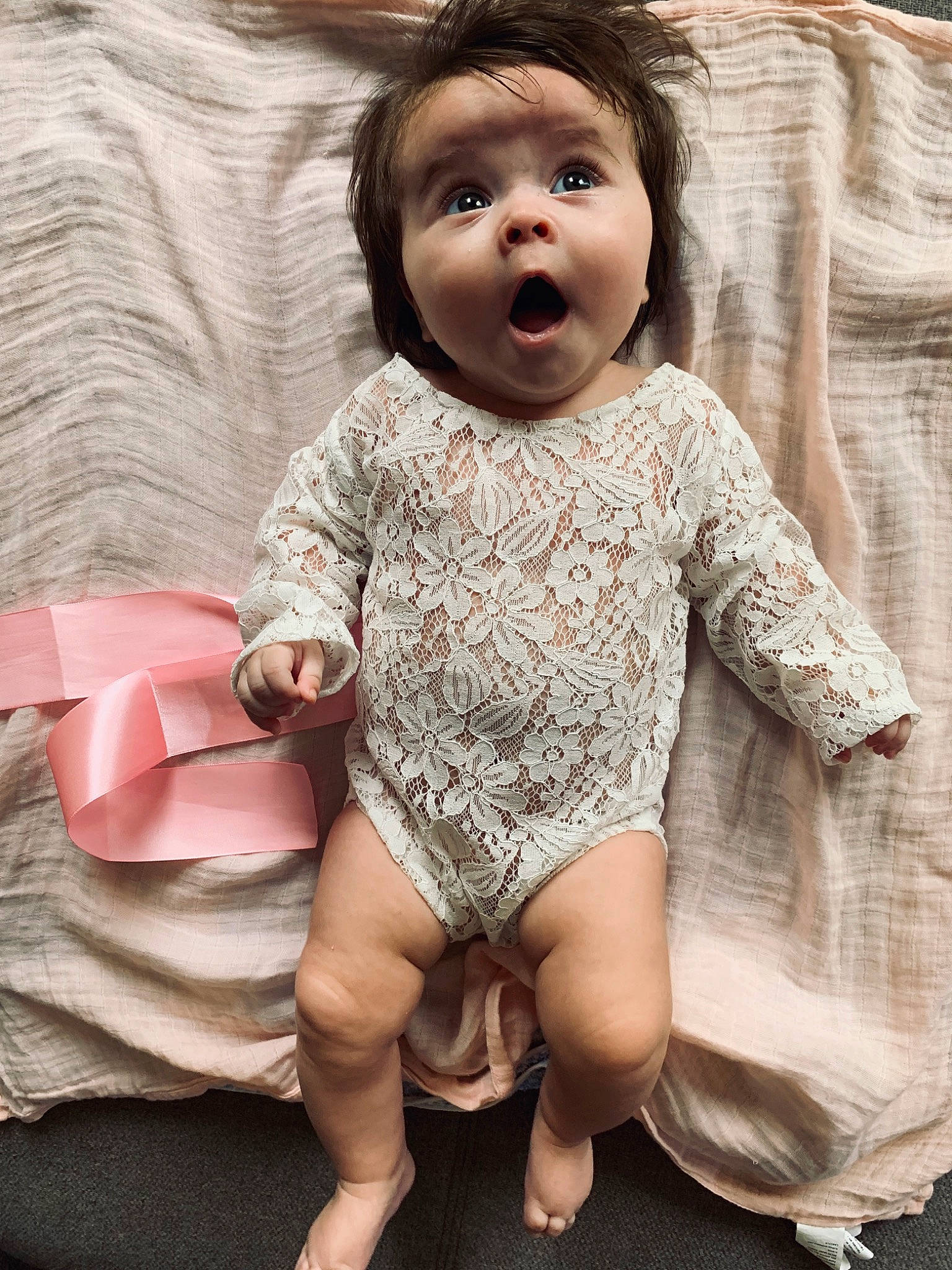 Louna participe au concours pour gagner de l'argent avec cette photo : arm, baby, baby_toddler_clothing, cheek, child, child_model, face, facial_expression, head, leg, person, pink, sitting, skin, sleeve, smile, surprise, toddler