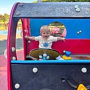 Octavius joined the competition — help win amazing prizes! bench, blonde_hair, blue_sky, child, daylight, fence, fun, grass, happy, outdoor, park, play_structure, playground, recreation, short_sleeve_shirt, smiling, steering_wheel, toddler, toy_vehicle, trees