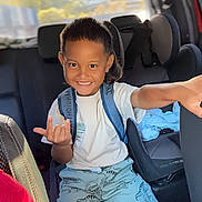 Tepoeanuiohiva a rejoint le concours — aidez-le/la à gagner de superbes lots ! child, boy, smile, backseat, car_interior, car_seat, backpack, dinosaur_shorts, white_tshirt, shorts, short_hair, hand_gesture, pointing, happy, portrait, sunlit, window, road_trip, family, upholstery