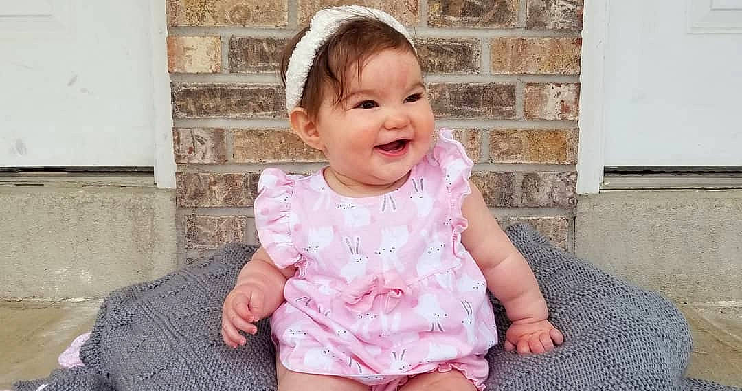 Lorena is registered to the contest to win money with this photo: baby, baby_toddler_clothing, beauty, cheek, child, dress, face, facial_expression, happy, head, headgear, joy, lip, nose, pattern, person, pink, sitting, skin, sleeve
