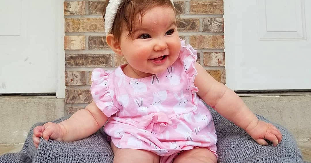 Lorena joined the competition — help win amazing prizes! baby, baby_toddler_clothing, cheek, child, clothing, design, dress, facial_expression, head, headgear, nose, pattern, person, pink, product, sitting, skin, sleeve, smile, textile