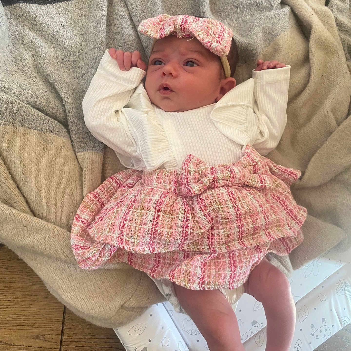Ruby-Leigh is registered to the contest to win money with this photo: adorable, baby, blanket, clothing, cute, expression, face, feet, headband, indoor, infant, legs, lying_down, newborn, patterned_blanket, pink, small_hands, soft_light, white, wooden_floor