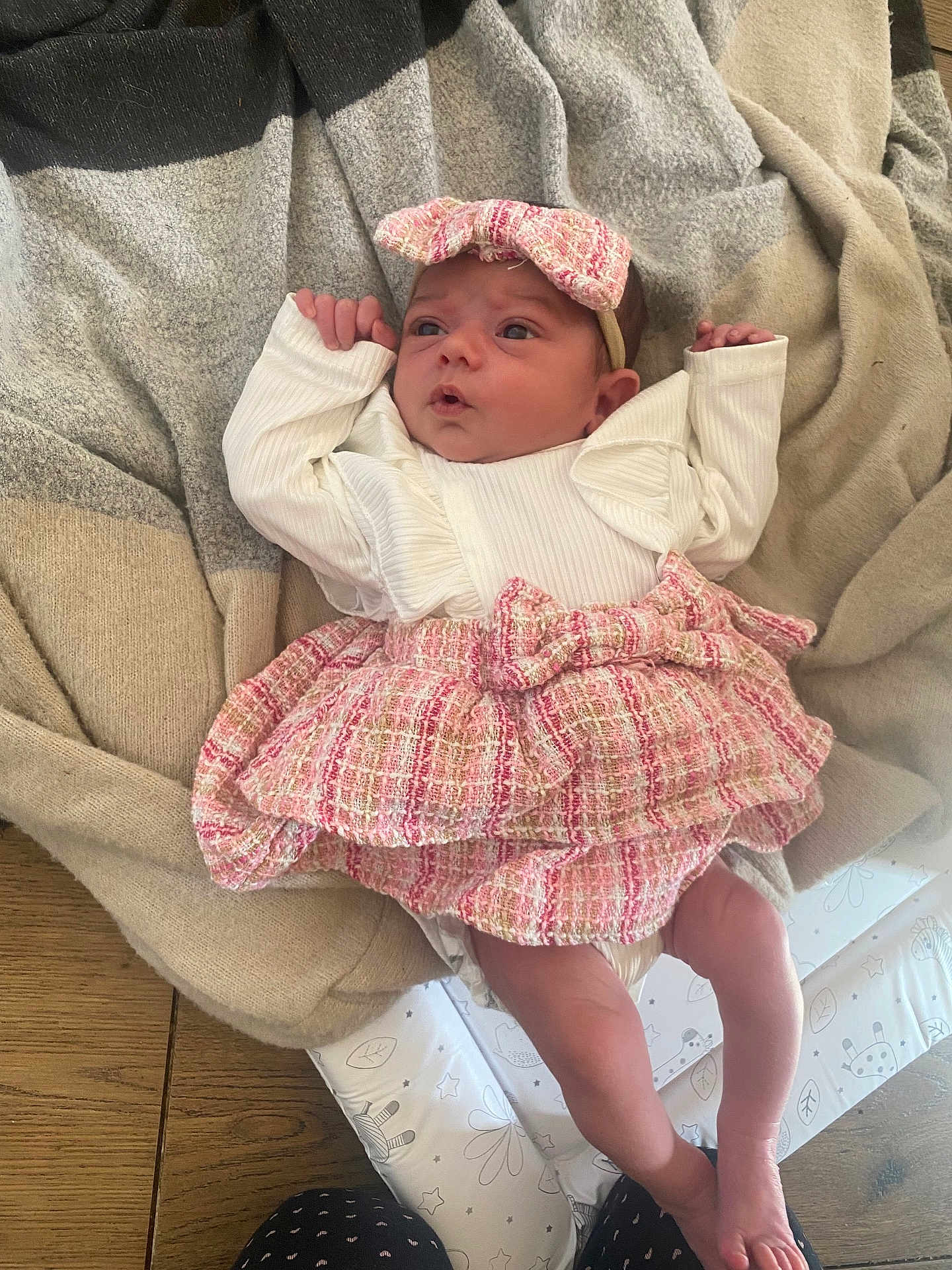 Ruby-Leigh is registered to the contest to win money with this photo: baby, infant, newborn, blanket, headband, pink, white, clothing, cute, lying_down, indoor, soft_light, wooden_floor, patterned_blanket, small_hands, expression, face, legs, feet, adorable