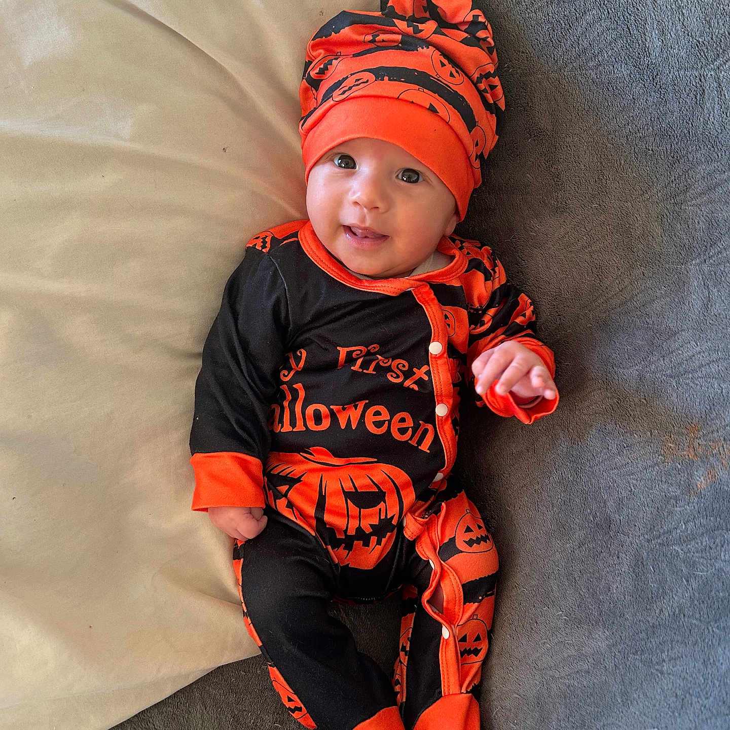 Gabriel participe au concours pour gagner de l'argent avec cette photo : apparel, baby, black, blanket, child, costume, cute, footed_pajamas, halloween, happy, hat, indoors, infant, jack_o_lantern, lying_down, one_person, orange, pillow, portrait, smile