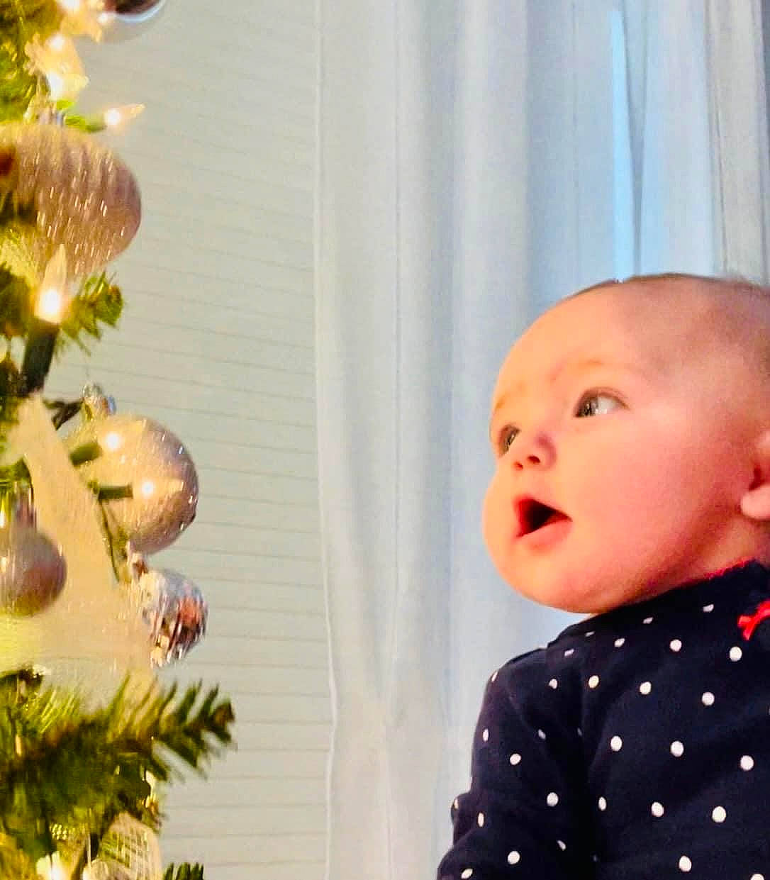Kaycee Maria Grace is registered to the contest to win money with this photo: baby, baby_toddler_clothing, christmas_decoration, christmas_ornament, christmas_tree, conifer, event, evergreen, fun, happy, holiday, holiday_ornament, lighting, nose, ornament, person, plant, room, toddler, white