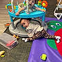 James is registered to the contest to win money with this photo: baby, toddler, child, playmat, activity_center, toys, indoor, carpet, colorful, crawling, playtime, smiling, cute, clothing, sock, furniture, floor, expression, young_child, home