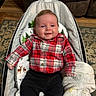 Gunner is registered to the contest to win money with this photo: baby, infant, smiling, plaid_shirt, black_pants, baby_rocker, blanket, forest_pattern, deer_pattern, carpet, couch, wood_floor, indoor, child, happy, portrait, seated, cozy, cute, person