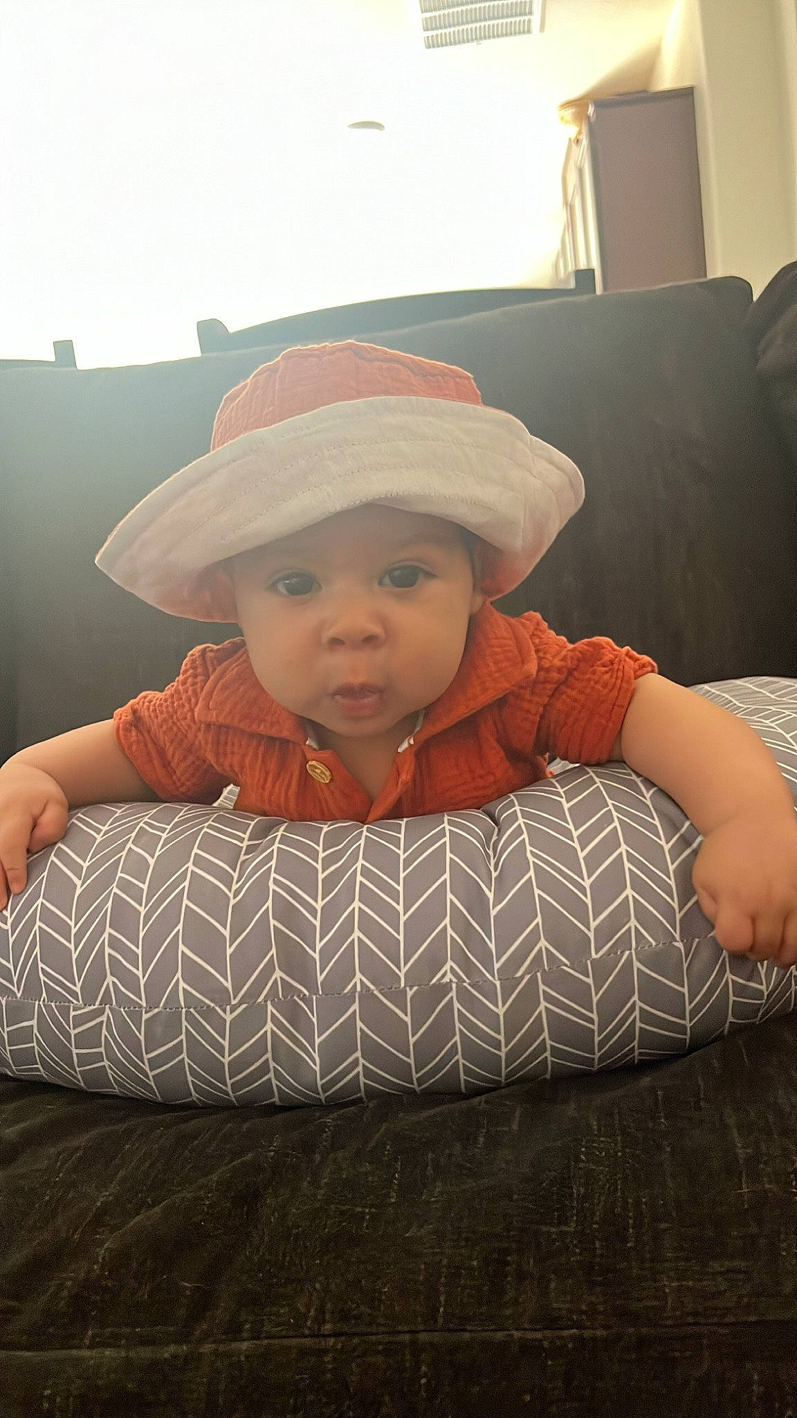 Cyrus joined the competition — help win amazing prizes! baby, baby_toddler_clothing, cap, cheek, child, comfort, fashion_accessory, flooring, fun, hat, head, headwear, linens, lip, pattern, person, room, sitting, sleeve, sun_hat