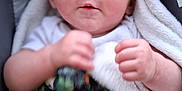 Delanie is registered to the contest to win money with this photo: baby, infant, blanket, car_seat, child, face, hands, curious, indoors, portrait, safety_label, clothing, soft_texture, expression, young_child, seated, closeup, human, person, cute