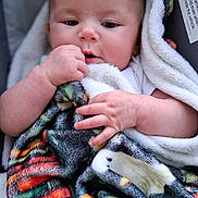 Delanie joined the competition — help win amazing prizes! baby, infant, blanket, hand, face, skin, cute, child, cozy, soft, warm, colorful, pattern, portrait, expression, young, wrapped, indoors, comfort, clothing