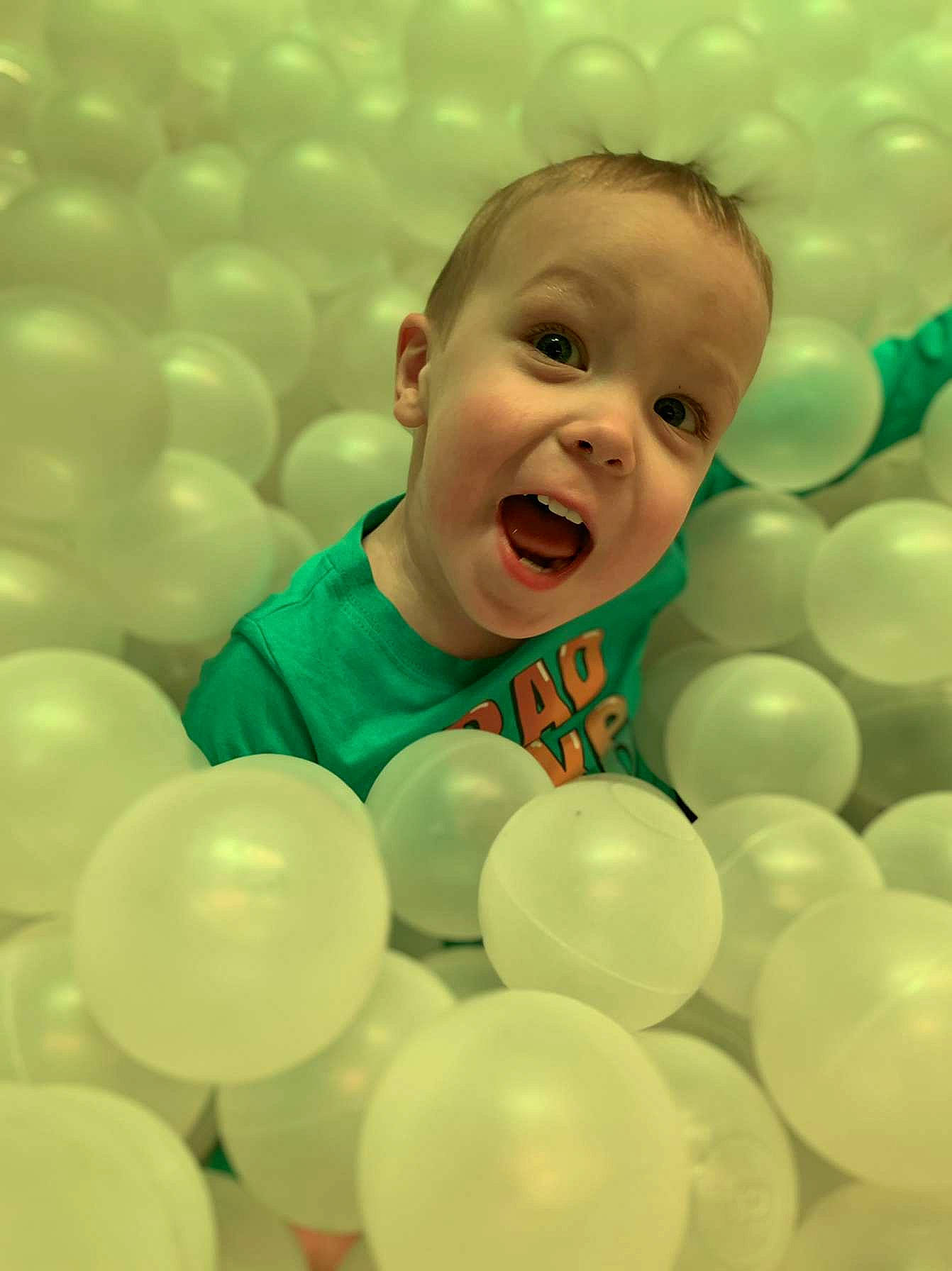 Axl is registered to the contest to win money with this photo: baby, baby_toddler_clothing, ball_pit, balloon, child, circle, event, facial_expression, font, fun, happy, head, human, laugh, people_in_nature, person, portrait_photography, product, smile, surprise