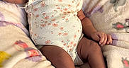 Naomi is registered to the contest to win money with this photo: baby, infant, sleeping, onesie, headband, blanket, patterned_blanket, pink, floral, socks, bow, cute, soft, child, newborn, resting, person, indoors, cozy, small