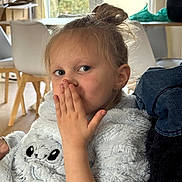 Célèste a rejoint le concours — aidez-le/la à gagner de superbes lots ! child, girl, indoor, sweater, hand, face, hair, messy_bun, playful, furniture, window, chair, table, light, cozy, portrait, expression, cute, casual, home