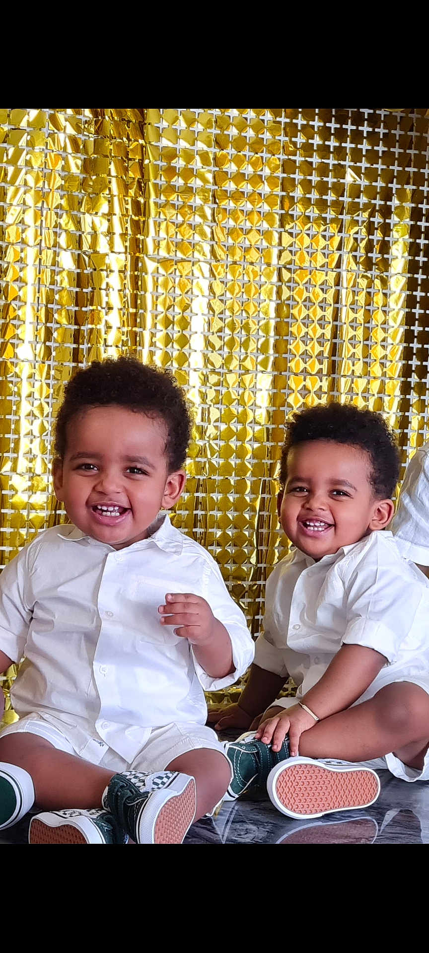 Yoas Et Noah a rejoint le concours — aidez-le/la à gagner de superbes lots ! toddler, child, smiling, white_shirt, sneakers, sitting, floor, gold_backdrop, happy, portrait, cute, indoor, two_children, curly_hair, casual_clothing, playful, young, people, friends, joy