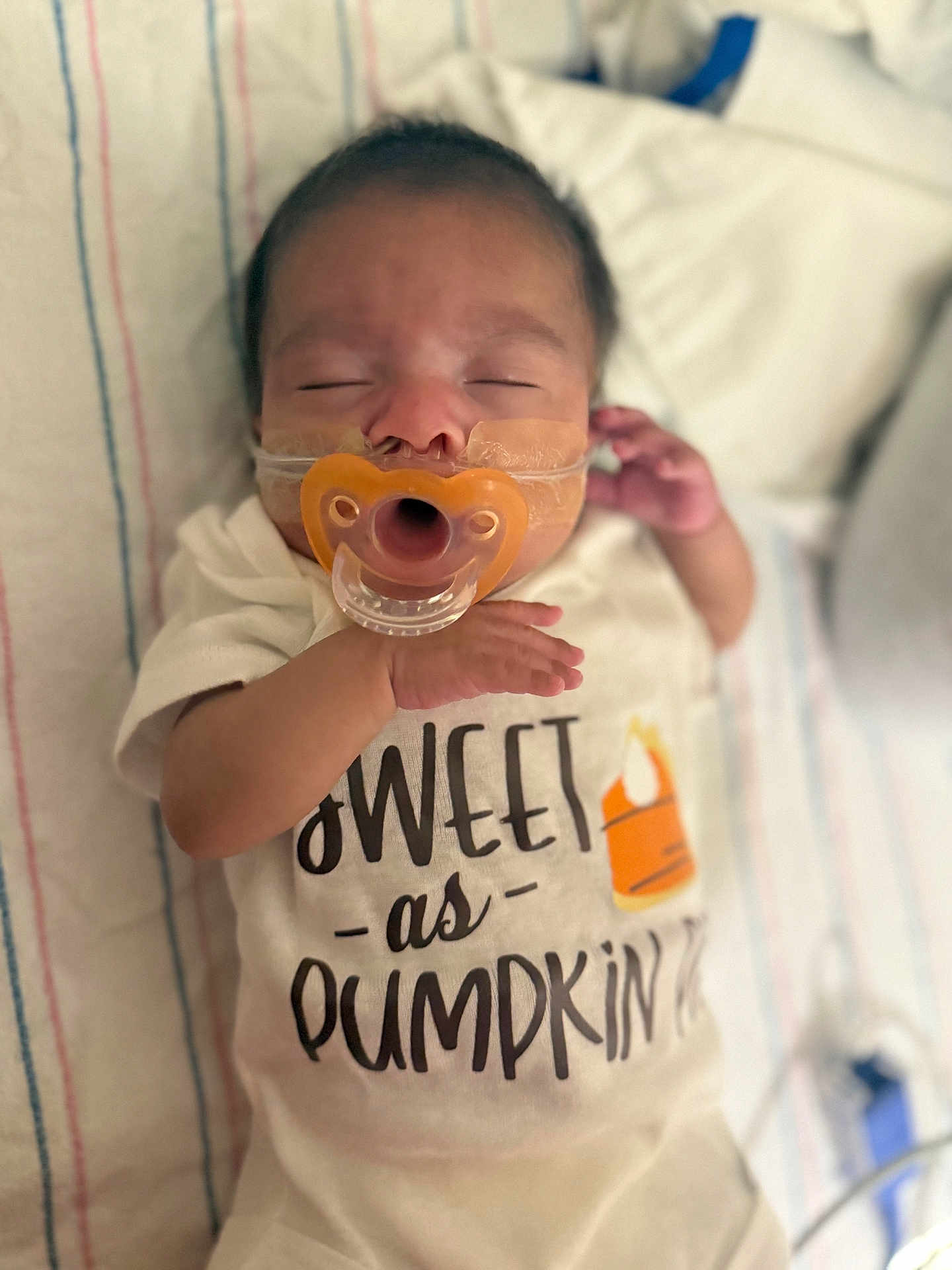Psalms joined the competition — help win amazing prizes! baby, infant, pacifier, sleeping, onesie, text_on_clothing, blanket, striped, hand, face, closeup, cute, resting, newborn, child, indoors, soft_lighting, peaceful, portrait, young