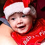 baby, child, santa_hat, red_clothing, smiling, close_up, portrait, holiday, christmas, festive, cute, infant, happy, person, face, headwear, adult_arm, celebration, seasonal, holding