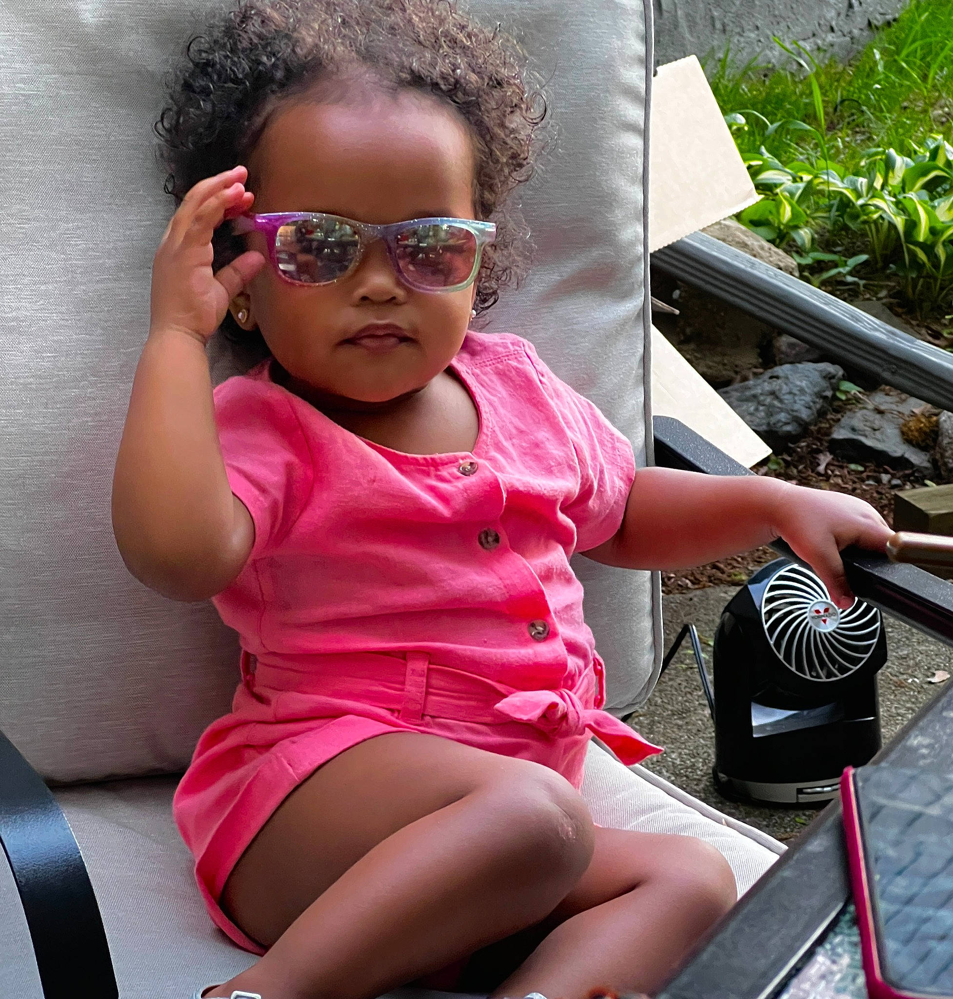 Arya is registered to the contest to win money with this photo: baby_toddler_clothing, black_hair, eyewear, glasses, goggles, hair, happy, head, human_leg, leg, leisure, lip, magenta, person, pink, plant, skin, sunglasses, thigh, toddler
