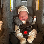 Jaden is registered to the contest to win money with this photo: newborn, baby, car_seat, infant, sleeping, clothing, hat, pajamas, straps, buckle, fabric, seat, child, person, cozy, cute, small, resting, indoors, safety