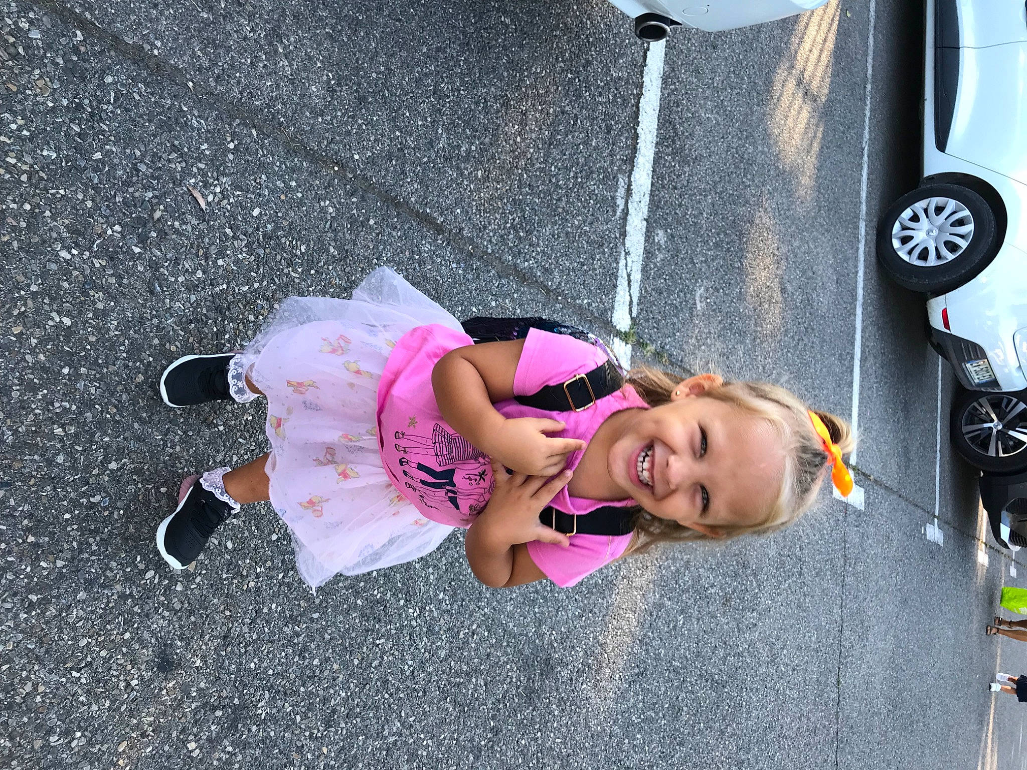 Cylia participe au concours pour gagner de l'argent avec cette photo : asphalt, automotive_design, automotive_exterior, automotive_tire, bumper, eyewear, family_car, fun, hat, joy, leisure, magenta, motor_vehicle, person, public_space, road, road_surface, sidewalk, smile, toddler