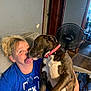 Layla is registered to the contest to win money with this photo: woman, dog, indoor, couch, affection, licking, brindle_dog, pink_collar, blue_shirt, casual, living_room, fan, wood_floor, door, human, pet, comfort, happy, interaction, relaxed