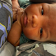 Milo is registered to the contest to win money with this photo: baby, infant, close_up, face, child, carrier, padded, comfort, curious, hand, skin, young, indoor, soft, portrait, clothing, straps, babywearing, expression, casual