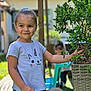 Hel a rejoint le concours — aidez-le/la à gagner de superbes lots ! child, girl, outdoor, plant, leafy_plant, basket, unicorn_tshirt, smiling, happy, garden, greenery, sunny, playing, nature, person, short_sleeves, patterned_pants, toy, blurred_background, daylight