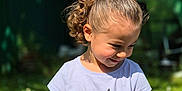 Hel participe au concours pour gagner de l'argent avec cette photo : child, girl, smiling, curly_hair, ponytail, tshirt, unicorn, cat_face, outdoor, garden, sunny, greenery, blue_sky, casual_clothing, sitting, happy, cute, daylight, playful, nature
