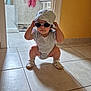 Ivanna participe au concours pour gagner de l'argent avec cette photo : toddler, child, hat, sunglasses, squatting, white_clothing, shoes, indoor, tile_floor, bathroom, towel, cabinet, yellow_wall, cute, fashion, baby, person, floor, home, casual