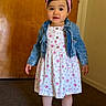 toddler, child, girl, indoor, dress, floral_pattern, denim_jacket, headband, flower_accessory, white_shoes, socks, carpet, door, wall, standing, portrait, cute, young_child, fashion, smiling