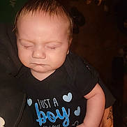 Lucas is registered to the contest to win money with this photo: arm, baby, background, child, chubby_cheeks, close_up, dog, face, flash, hand, holding, indoor, infant, onesie, person, pet, portrait, sleeping, tattoo, text_on_clothing