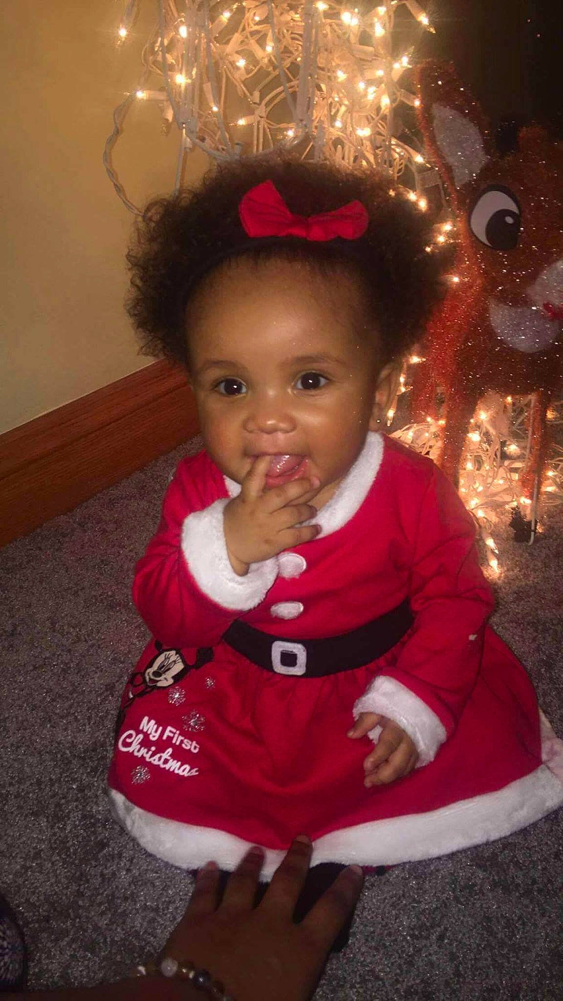 Khloe is registered to the contest to win money with this photo: child, christmas, event, fun, girl, holiday, infant, lap, person, product, smile, toddler