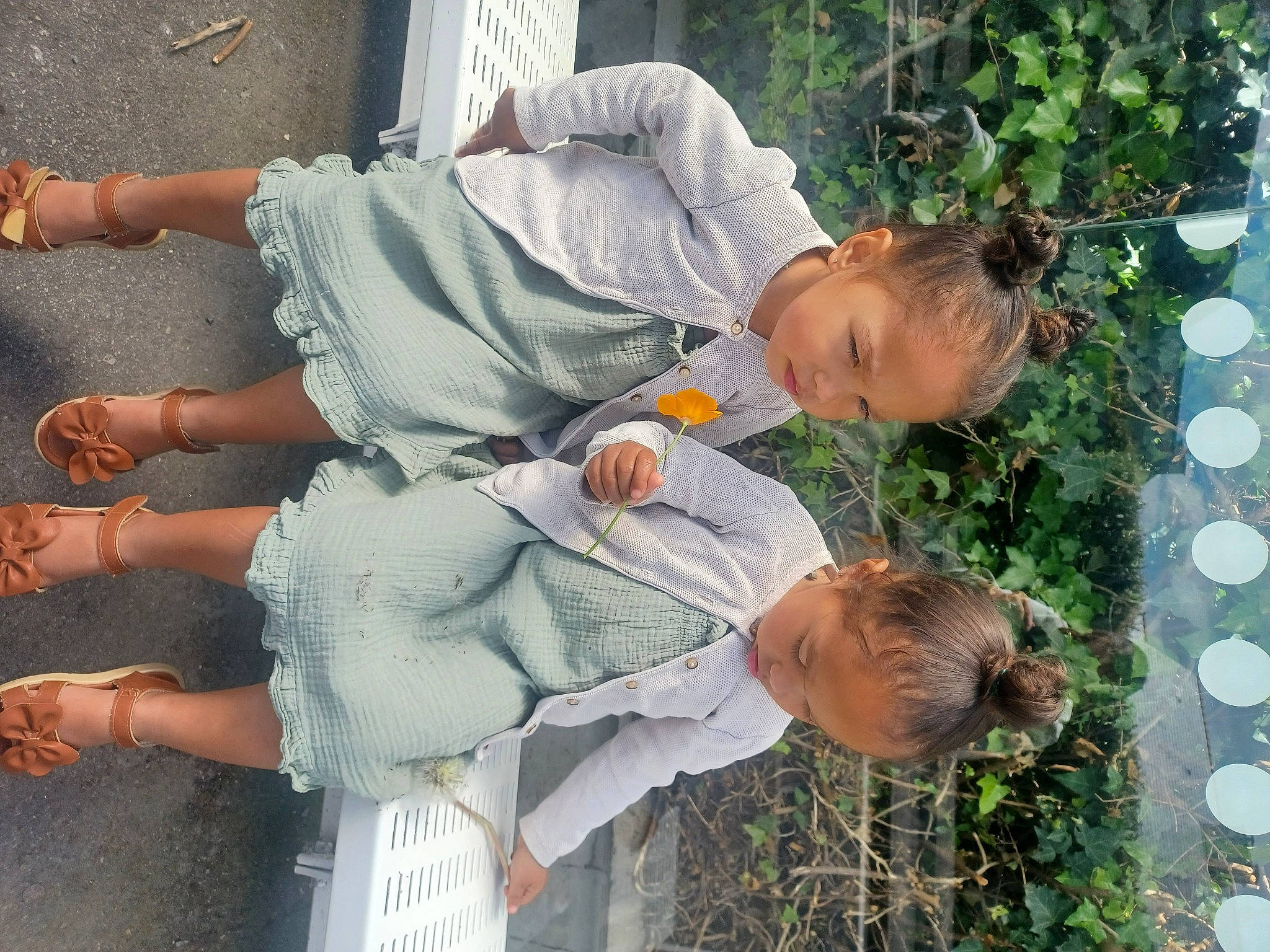 Jayanah a rejoint le concours — aidez-le/la à gagner de superbes lots ! barefoot, child, facial_expression, foot, fun, gesture, grass, happy, human_leg, interaction, knee, leisure, people_in_nature, person, plant, sandal, sidewalk, sunglasses, thigh, toddler