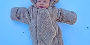 Jace is registered to the contest to win money with this photo: animal_ears, baby, blue, child, cold, costume, cute, face, fuzzy, headwear, infant, lying_down, onesie, outdoor, person, playful, snow, tongue, warm_clothing, winter
