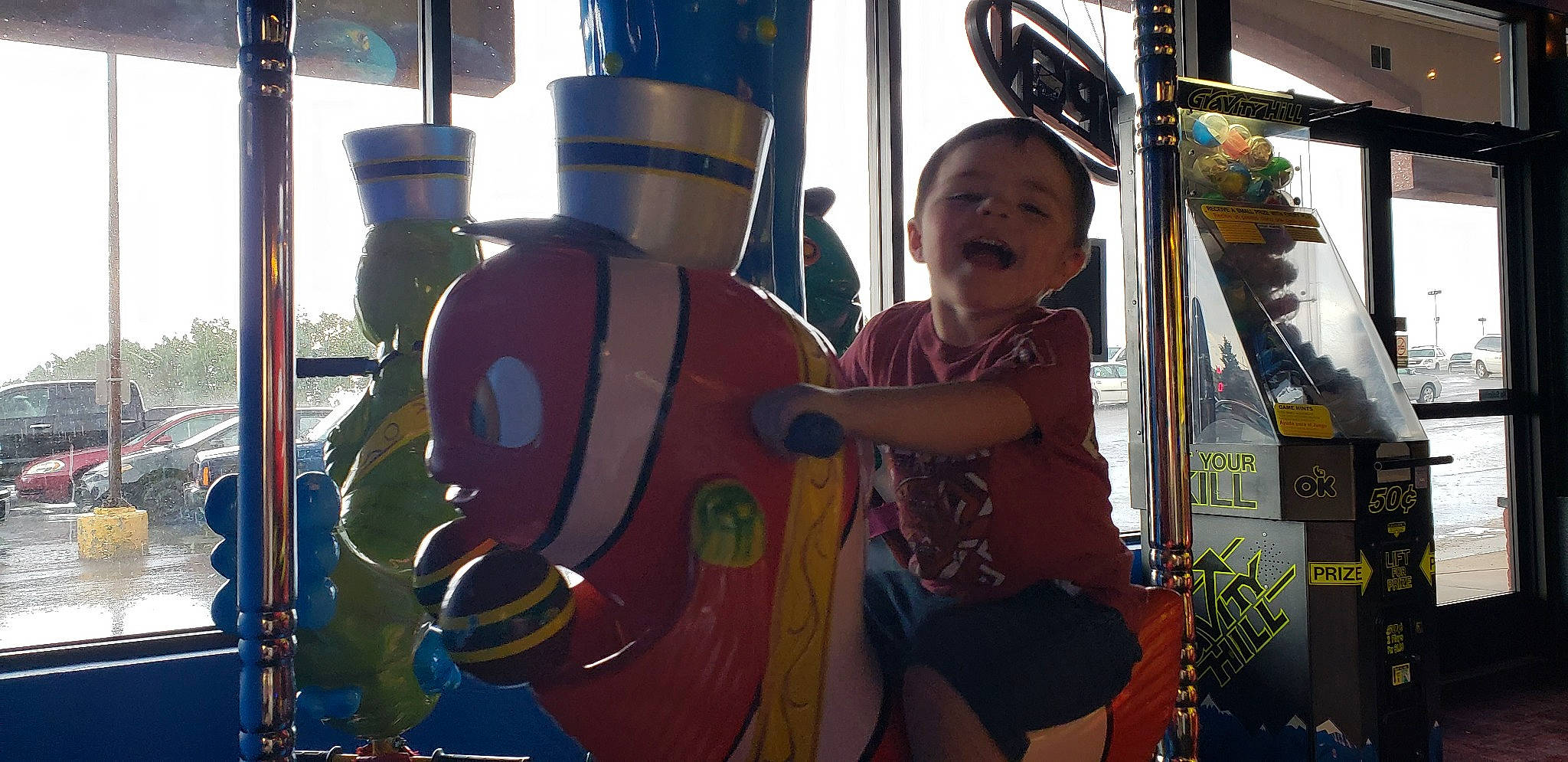 Jaxson is registered to the contest to win money with this photo: amusement_park, amusement_ride, carousel, child, fun, leisure, nonbuilding_structure, park, person, playground, recreation, smile, toddler, vacation