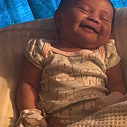 Skylar is registered to the contest to win money with this photo: baby, smiling, blanket, mittens, cute, indoor, child, sleepy, cozy, clothing, face, portrait, young, resting, infant, happy, person, fabric, bed, curtain