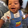 toddler, child, smiling, curly_hair, toy_story, overalls, reaching_out, happy, indoor, clothing, face, person, cute, apparel, young_child, portrait, closeup, baby, cheerful, colorful