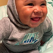Jeremiah joined the competition — help win amazing prizes! baby, infant, smiling, hoodie, nike, grey_clothing, happy, cute, closeup, indoors, soft_blanket, sitting, child, face, portrait, young, joyful, cozy, apparel, expression