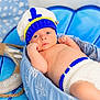 Cruz is registered to the contest to win money with this photo: baby, infant, crochet_hat, crochet_diaper_cover, blue, basket, nautical, life_preserver, stars_pattern, background, cute, lying_down, portrait, soft_lighting, newborn, child, indoors, decor, blue_bedding, relaxing
