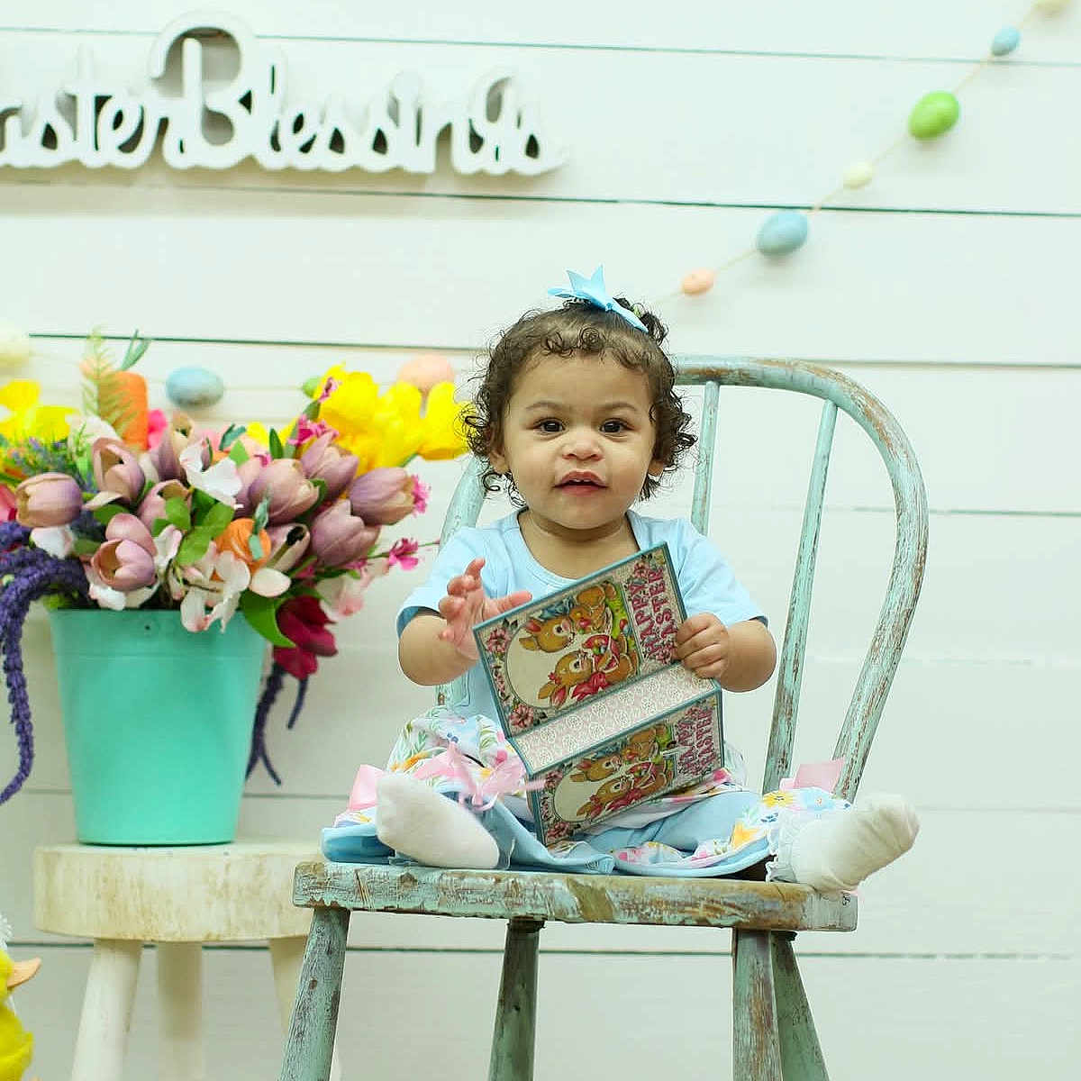 Kaylzn joined the competition — help win amazing prizes! blue_bow, carpet, chair, child, curly_hair, decorations, easter_card, easter_eggs, flower_vase, flowers, holiday, indoor, pastel_colors, person, portrait, smiling, spring, toddler, white_wall, wooden_chair