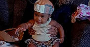 Azari'Yanna joined the competition — help win amazing prizes! adult, baby, casual, child, couch, cozy, family, furniture, glasses, hat, holding, home, indoor, jeans, person, portrait, seated, skirt, smiling, socks