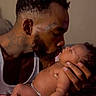 Azari'Yanna is registered to the contest to win money with this photo: affection, baby, beard, bond, closeup, diaper, expression, family, father, holding, indoor, kiss, love, man, newborn, portrait, relationship, skin, tattoo, tenderness
