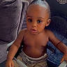 King is registered to the contest to win money with this photo: child, curly_hair, curtain, expression, eyes, face, floor, furniture, hairstyle, high_chair, home, indoor, person, seatbelt, shirtless, shorts, skin, sofa, toddler, window